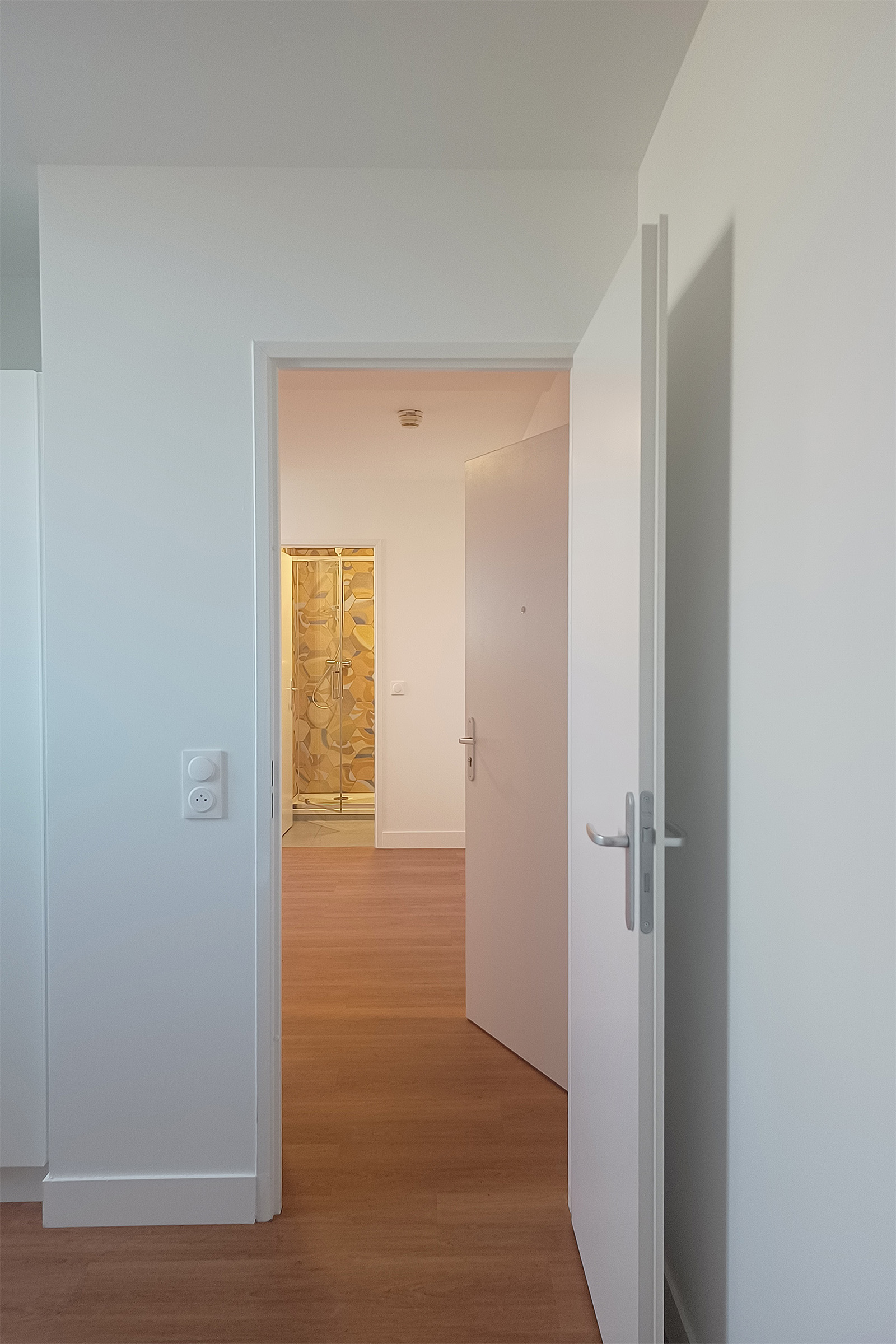 Chambre d’un logement réhabilité avec vue vers la salle de bains