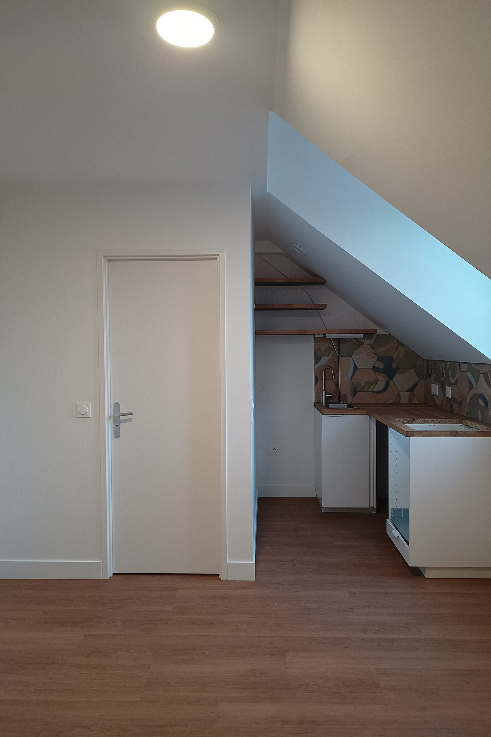 Cuisine aménagée sous rampant dans un logement réhabilité