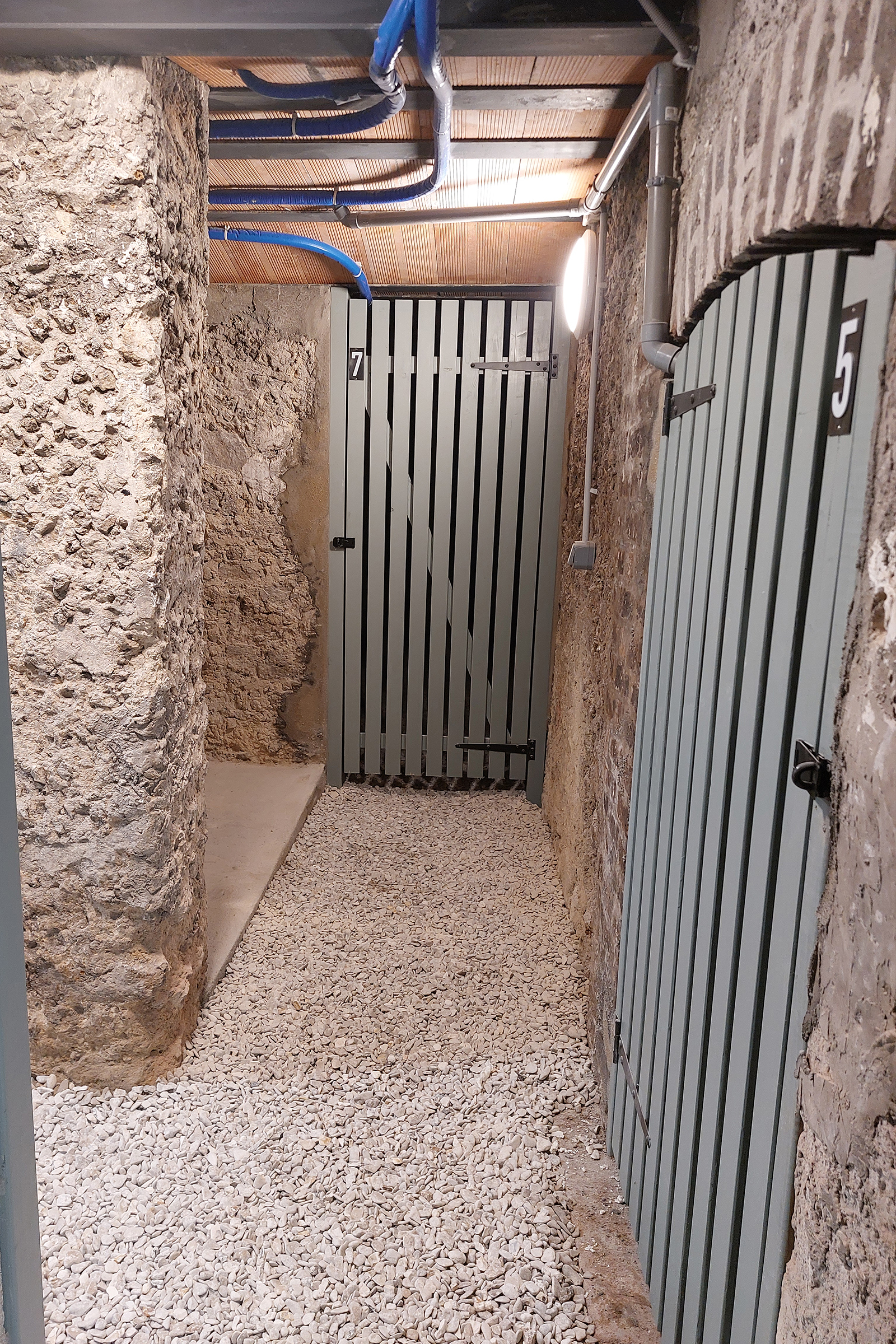 Caves assainies avec graviers roulés au sol et portes ajourées